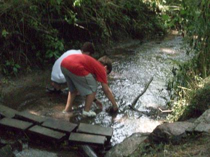 Two children playing in a creek.