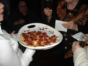 A person holding a plate of appetizers at an event.