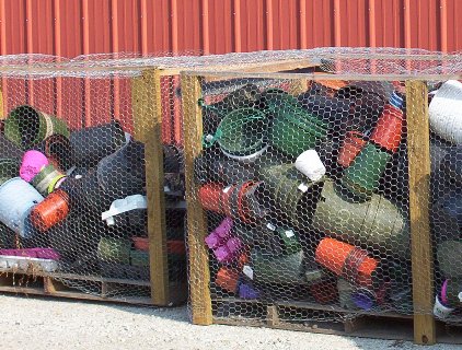 Wooden and metal fencing containers holding a variety of plastic buckets.