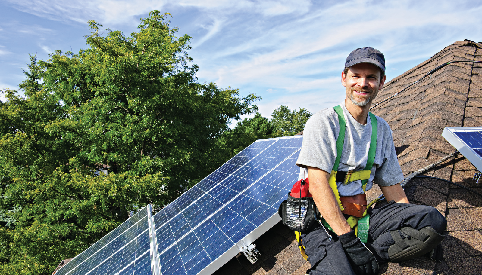 A man installing solar panels on a roof.