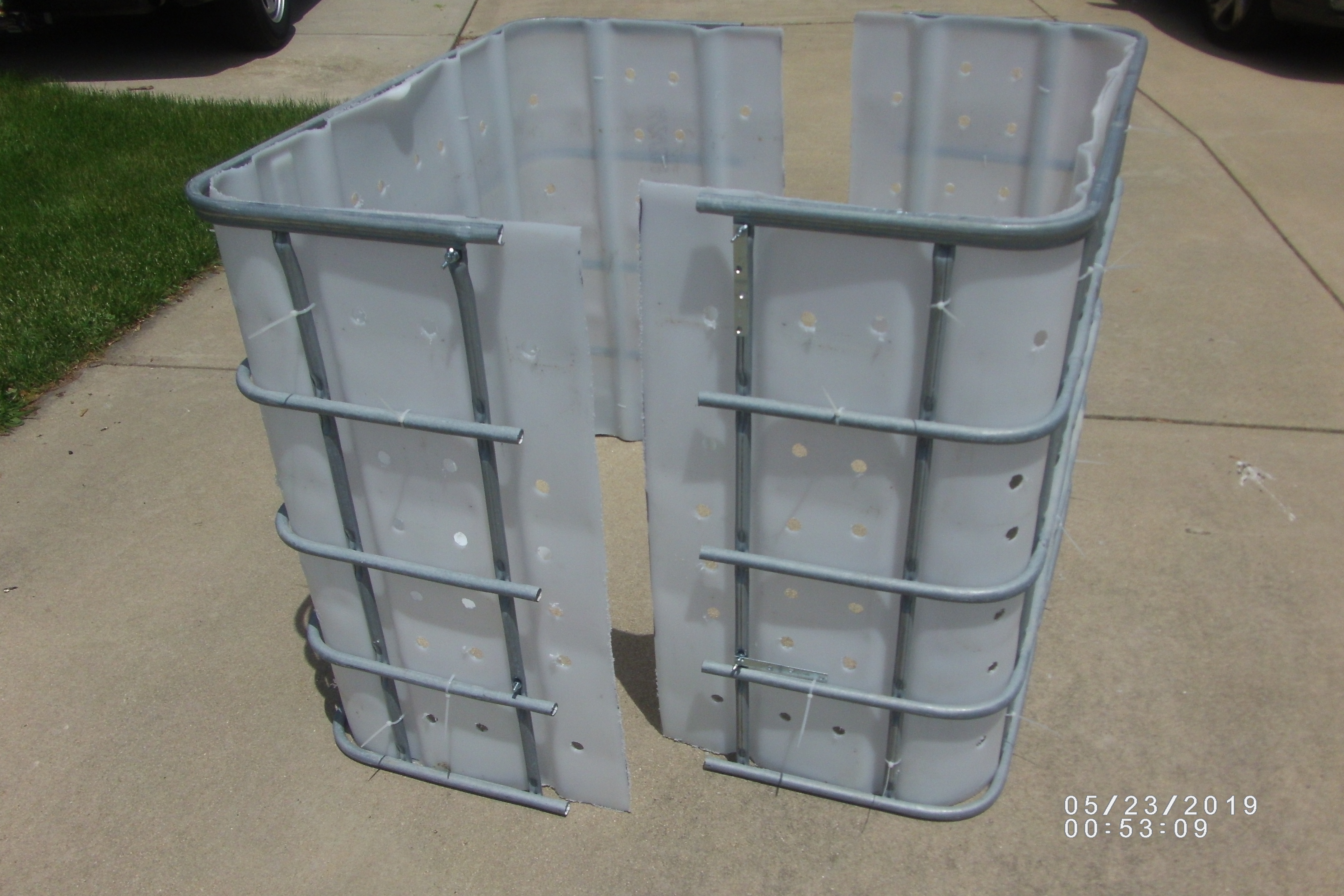 A white compost bin with a metal frame being built.