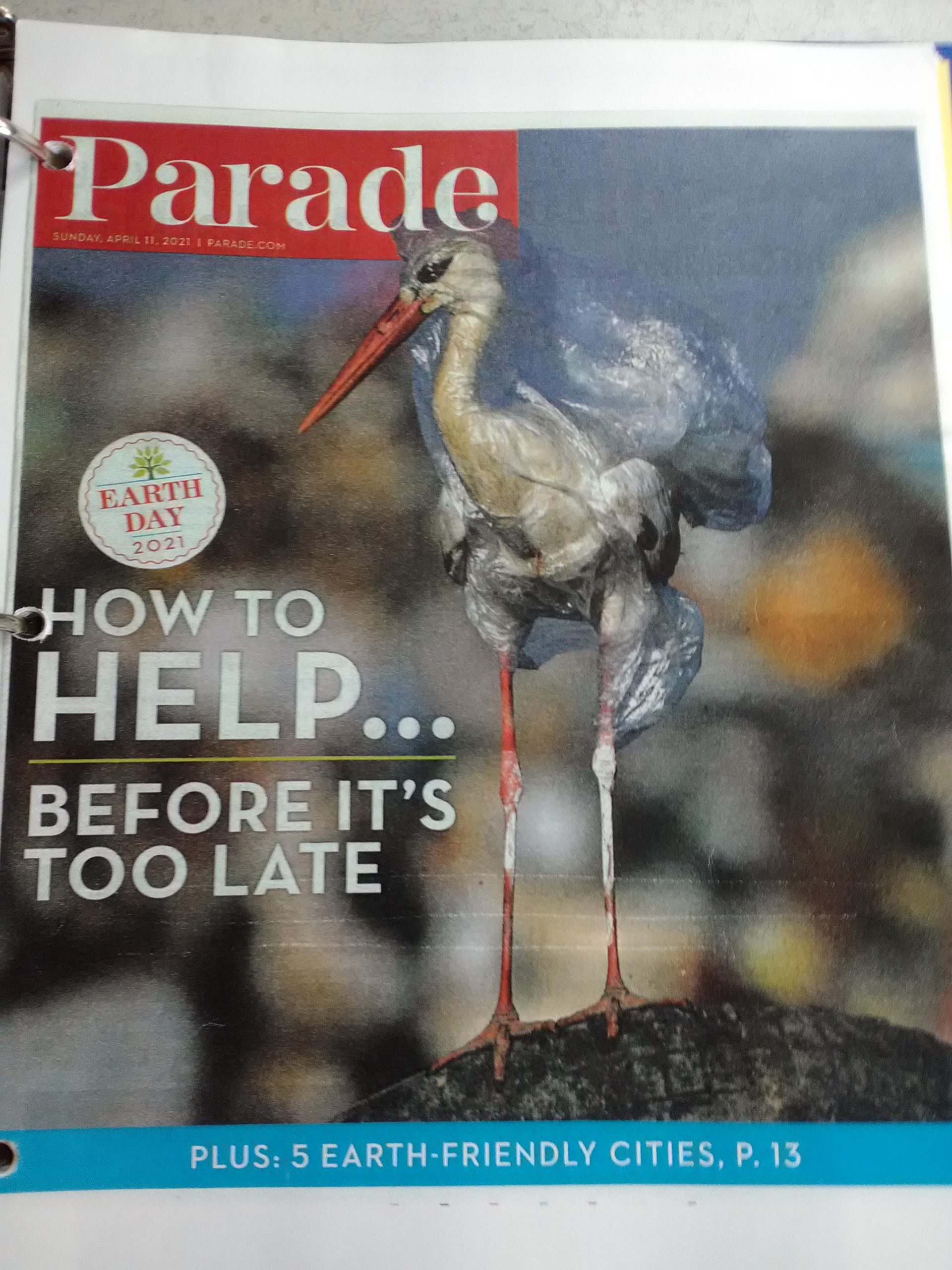 Cover of Parade magazine for Earth Day in 2021 featuring a bird wrapped in plastic waste