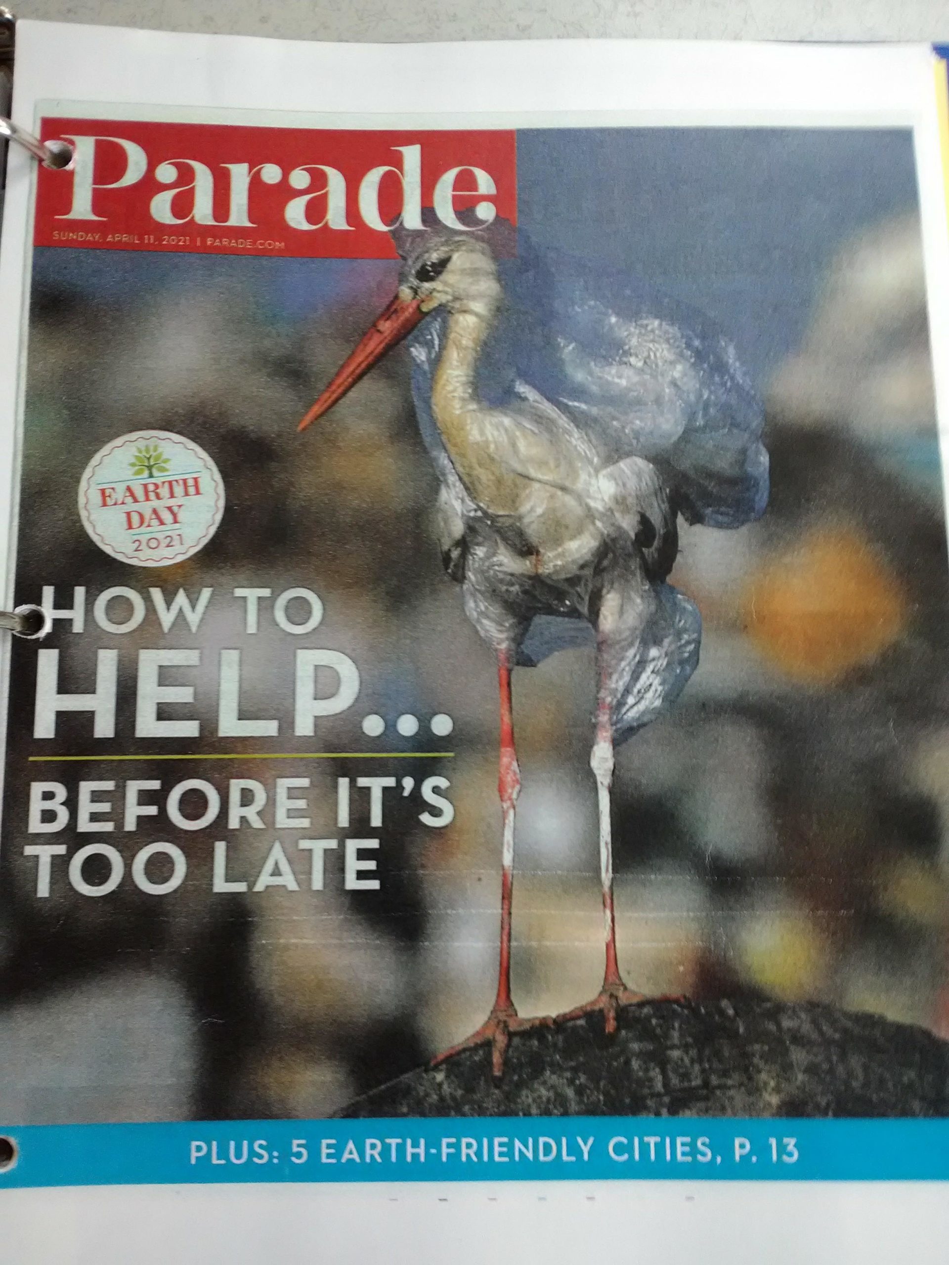 Parade Magazine cover featuring a bird wrapped in plastic waste for the Earth Day 2021 edition.