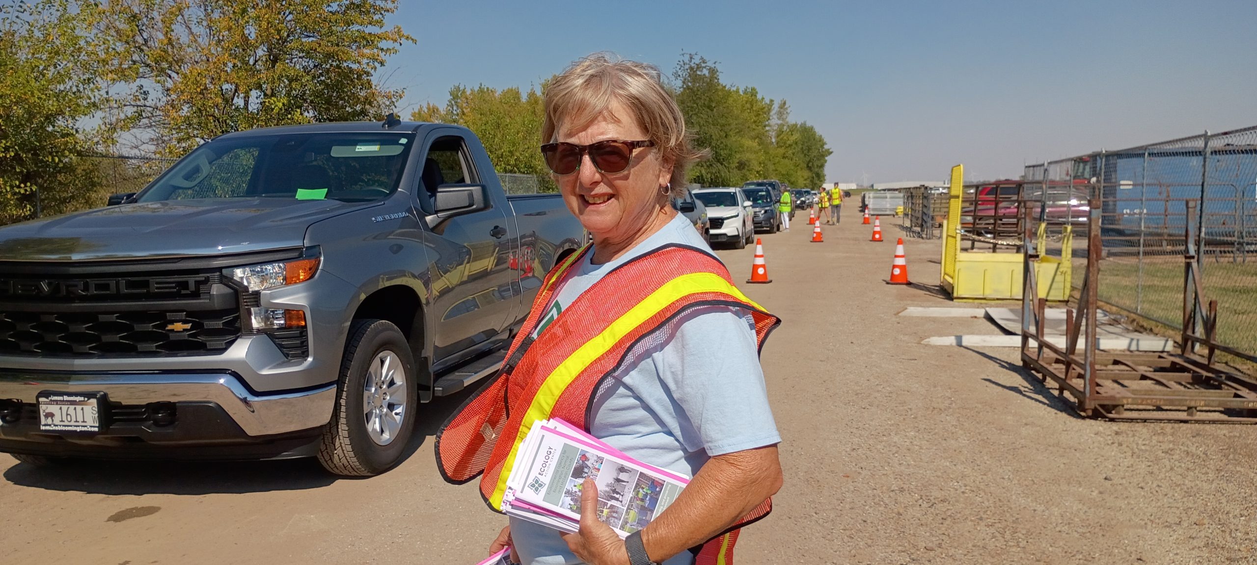 HHW volunteer with orange vest handing out pamphlets